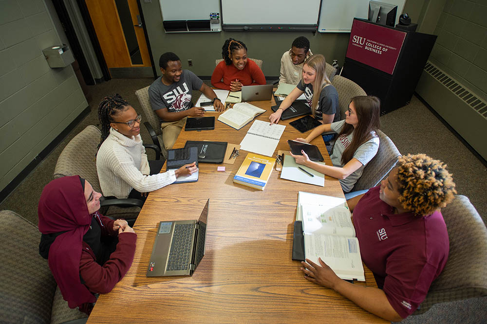 SIU Accounting students sit at table in class discussion